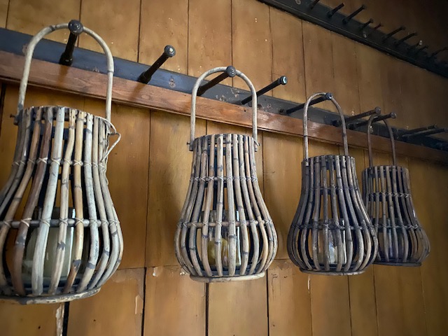 rattan lanterns hanging against wooden wall covering