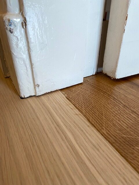 wooden plank floor laid under architraves